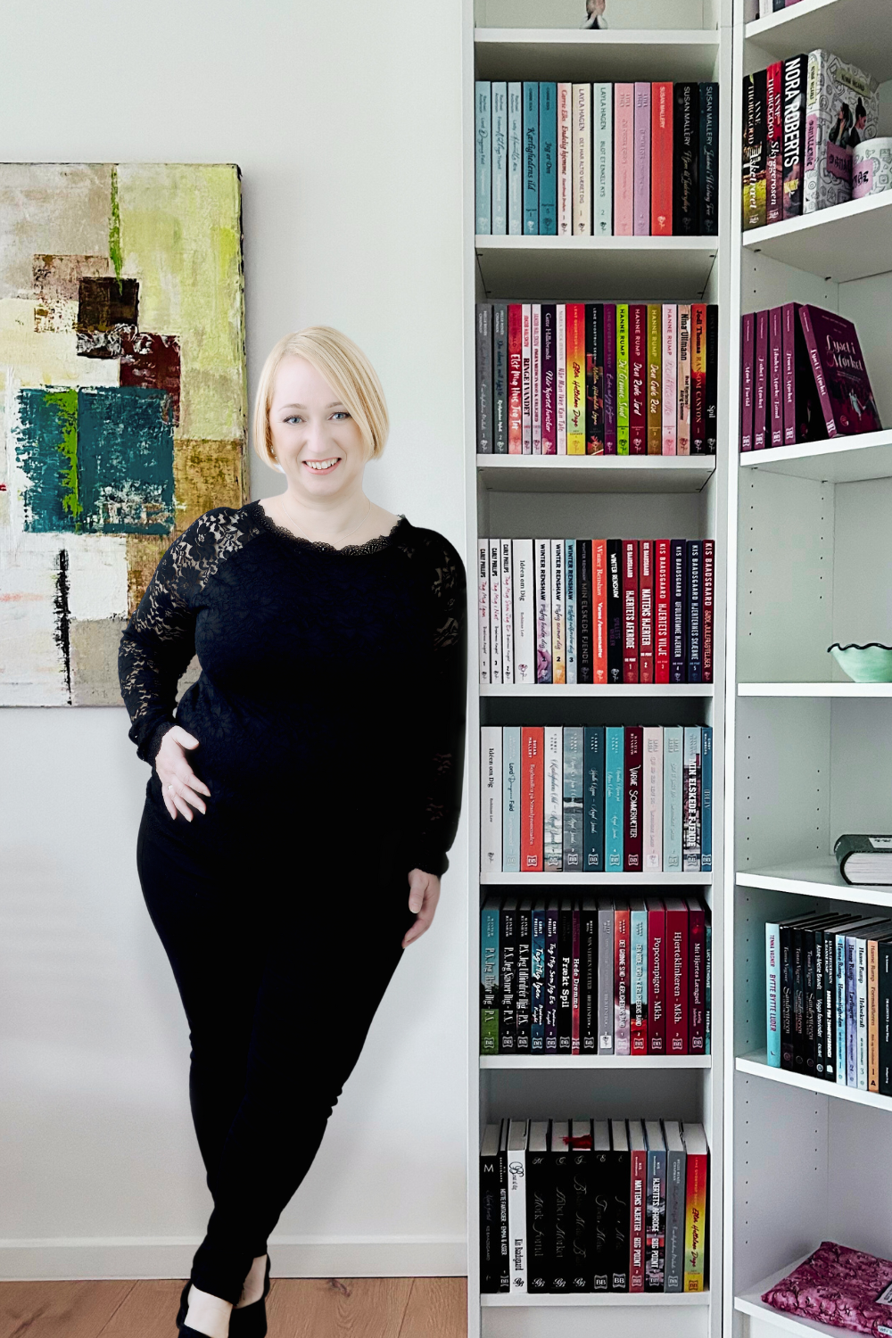 Forfatter, forlægger og korrekturlæser Vibeke Vestergaard ved sin bogreol